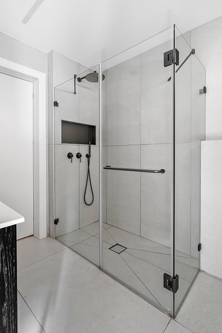 מקלחון פינתי זכוכית שקופה 8 מ"מ - שני קבועים ודלת עם פרזול בצבע גרפיט. 
כל סוגי המקלחונים בהתאמה אישית ללקוח